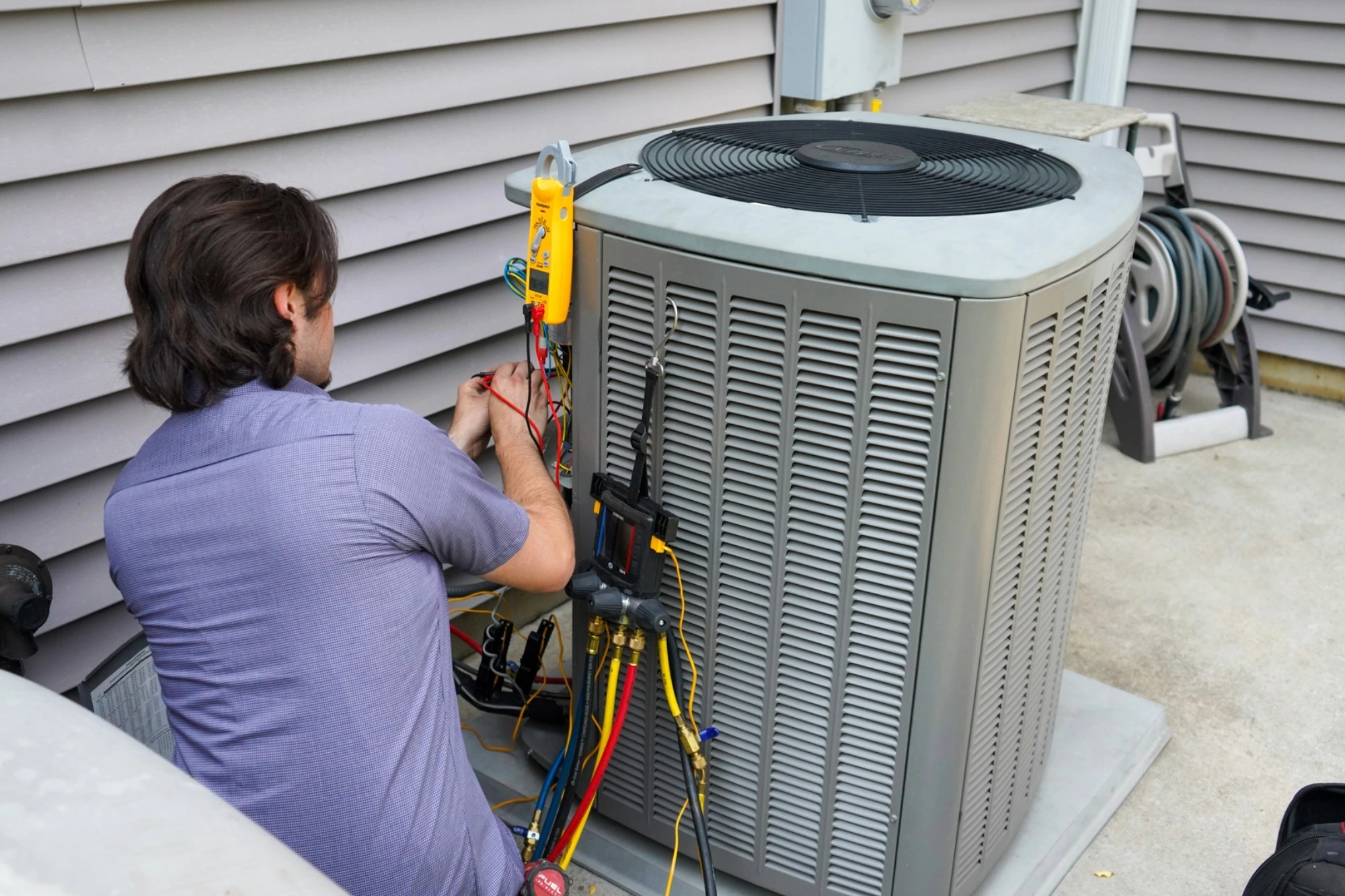 Eric Dale Heating and Air Conditioning Technician working on a air conditioning unit